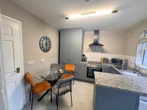 a kitchen with a glass table and some chairs at Bide A While at the Port in Portrush