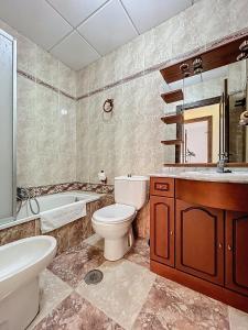 a bathroom with a toilet and a tub and a sink at Casa Patio de la Antigua in Iznájar +39 photos
