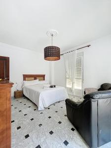 a bedroom with a bed and a couch at Casa Patio de la Antigua in Iznájar