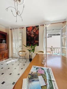 a living room with a table and a painting on the wall at Casa Patio de la Antigua in Iznájar