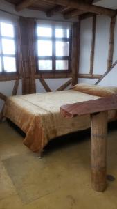 a large bed in a room with two windows at Torre de Guadua in Medellín