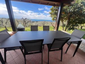 a black dining table and chairs on a patio at Villa Cà Bottura agli ulivi in Bardolino