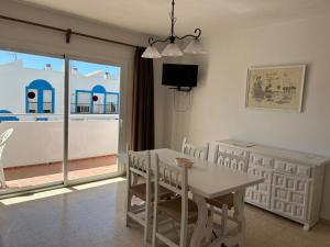a white dining room with a table and chairs at Apartamentos Alba in San Antonio Bay