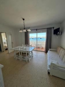 a living room with a table and a view of the ocean at Apartamentos Alba in San Antonio Bay +42 photos