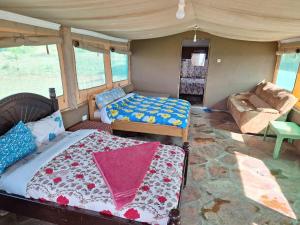 a bedroom with a bed and a couch in a room at Oloirien camps in Maasai Mara National Reserve