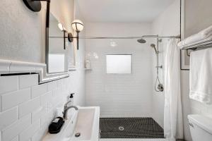 a white bathroom with a sink and a shower at The Little Bungalow in Houston +11 photos