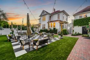 a patio with chairs and umbrellas in front of a house at The Little Bungalow in Houston