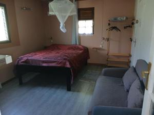 a bedroom with a bed and a couch in a room at Chez Myky in Sainte-Marie