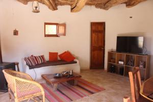 a living room with a couch and a tv at Casa Garces in San Pedro de Atacama