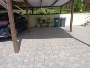 a parking lot with a car parked under a roof at Chez Myky in Sainte-Marie