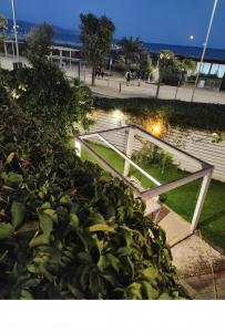 a garden with a wooden structure in the grass at Windofsand Room in Cagliari