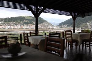 a restaurant with tables and chairs and a view of a mountain at Hotel Panorama in Berat +34 photos