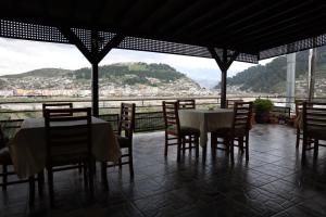 a dining room with a table and chairs and a view at Hotel Panorama in Berat