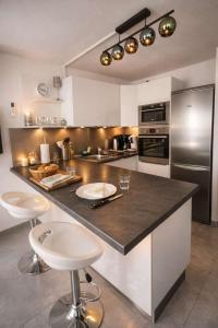 a kitchen with a large counter with stools in it at Studio cosy, Centre Port, Piscine, proche plage in Cap d'Agde