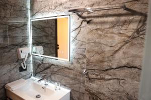 a bathroom with a sink and a mirror at Hotel Panorama in Berat