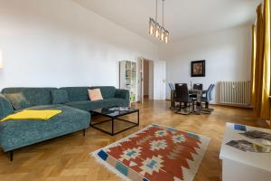 a living room with a green couch and a table at Fürstlich Wohnen am Circus mit Blick zur Granitz in Putbus