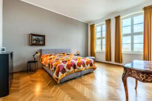 a bedroom with a bed and a table and windows at Fürstlich Wohnen am Circus mit Blick zur Granitz in Putbus