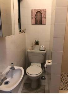 a bathroom with a white toilet and a sink at Beachfront Studio Flat in Cape Town +15 photos