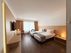 a hotel room with two beds and a table at Dazzler by Wyndham Lima Miraflores in Lima