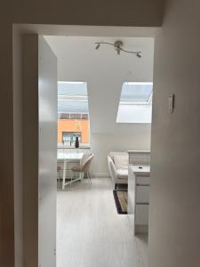 a white living room with a table and a couch at Penthouse Studio in Stockholm