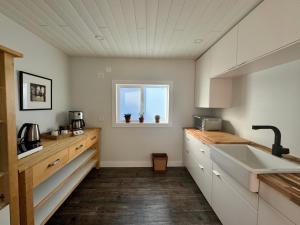 a kitchen with white cabinets and a sink and a window at Salt Spring Sunrise in Saltspring Island