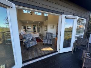 a screened in porch with chairs and a living room at Salt Spring Sunrise in Saltspring Island +11 photos