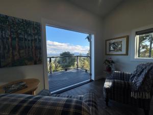 a living room with a view of a deck at Salt Spring Sunrise in Saltspring Island