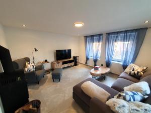 a living room with two couches and a tv at Domov na cestě in Rousovice