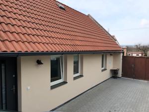 a house with a red roof and a courtyard at Domov na cestě in Rousovice