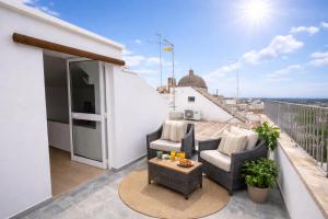 a balcony with two chairs and a table at Casa Vacanza Pietre & Cielo in Ceglie Messapica