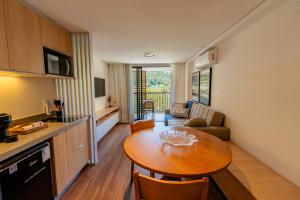 a kitchen and a living room with a table in a room at apartamento em Itaipava novo, Granja Brasil Resort in Petrópolis