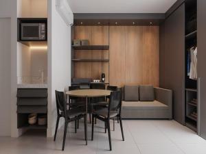 a dining room with a table and chairs and a couch at Flat em Porto life Resort in Porto De Galinhas