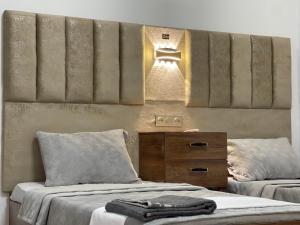 a bedroom with two beds and a wooden dresser at Hotel grosvenor in Saint-Arnaud