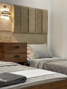 a bedroom with two beds and a dresser and a mirror at Hotel grosvenor in Saint-Arnaud