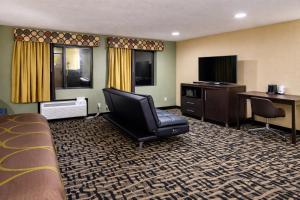a hotel room with a bed and a chair and a television at Super 8 by Wyndham Pasadena in Pasadena