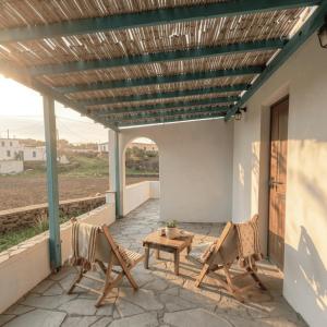 a patio with chairs and a table and awning at Under The Palm Tree - Boutique Stay Experience in Áno Meriá