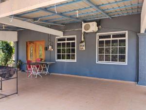 a room with a blue wall with a table and windows at Adeeva Homestay Langkawi in Pantai Cenang