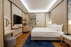 a hotel room with a bed and a television at Merit Crystal Cove Hotel Casino & SPA in Kyrenia