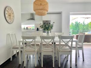 a kitchen with a white table and chairs and a clock at Theodora Residence in Balatonalmádi