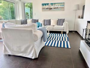 a living room with two white couches and a rug at Theodora Residence in Balatonalmádi