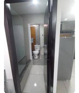 a bathroom with a toilet and a glass door at Duplex de la Sucre in Loja