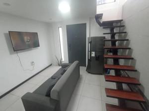 a living room with a couch and a tv at Duplex de la Sucre in Loja