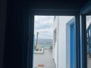 an open door to a balcony with a view of the ocean at Mykonos Port Apartment in Tourlos