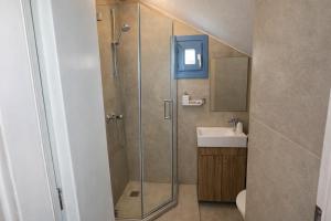 a bathroom with a shower and a sink at Mykonos Port Apartment in Tourlos