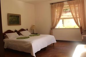 a bedroom with two beds and a window at Sítio p/ Casamentos 8 min do Centro de Petrópolis in Petrópolis