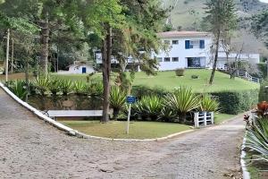 a house with a pond in front of a house at Sítio p/ Casamentos 8 min do Centro de Petrópolis in Petrópolis