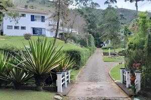 a driveway leading to a house with a white fence at Sítio p/ Casamentos 8 min do Centro de Petrópolis in Petrópolis