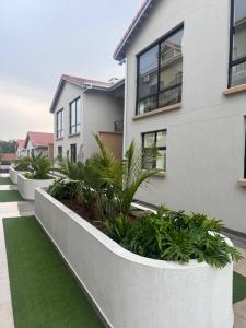a white building with plants in front of it at Gate Beautiful in Gaborone