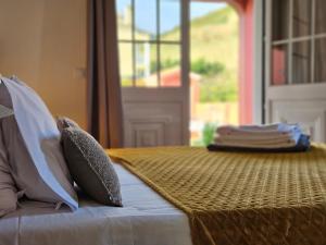 a bedroom with a bed with pillows and a window at A Casa do Comandante - Piscina e Jardim in Lagoa