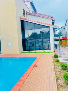 a building with a swimming pool in front of it at Gate Beautiful in Gaborone